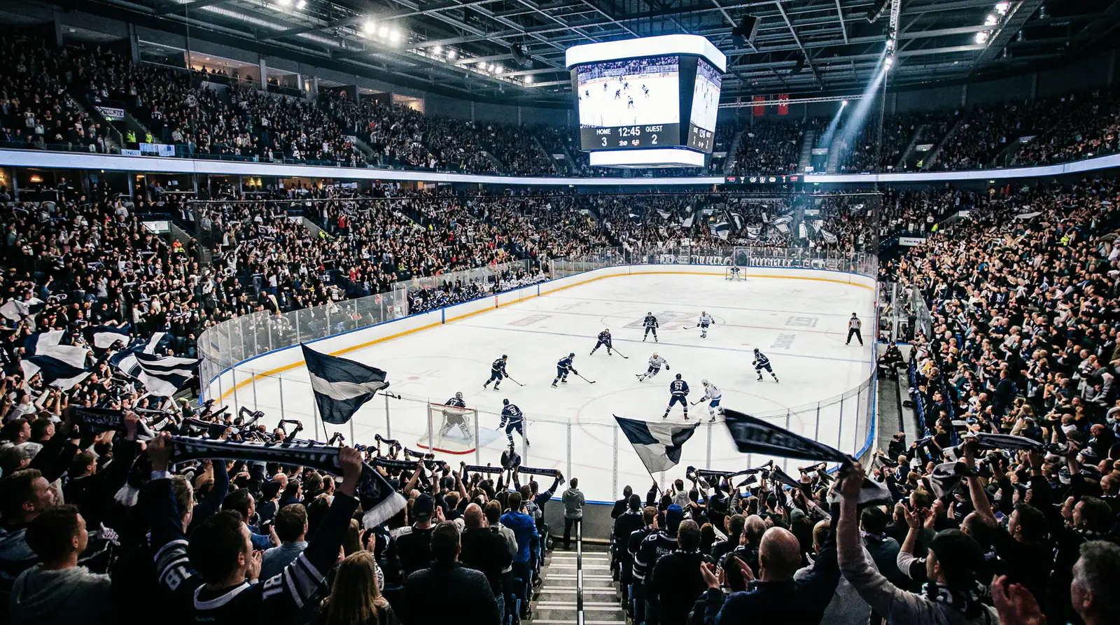 Ausverkauftes Eishockeystadion mit begeisterten Fans und Lichtshow auf dem Eis